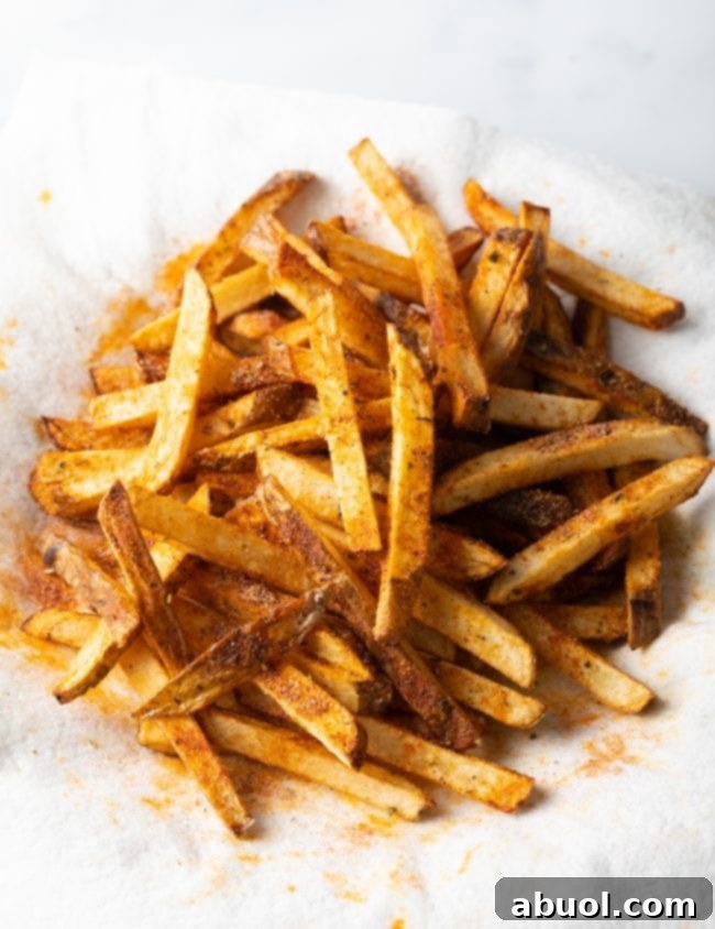 Top view sliced cajun seasoned fries on a white towel.