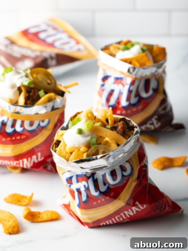 Bags of frito corn ships filled with chili, cheese, scallions and green onions plus jalapenos.