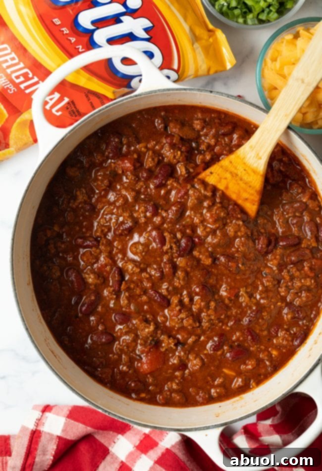 Top view finished pot of chili with wooden spoon.