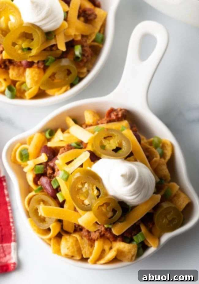 Top view Frito chili pie in a shallow white dish.