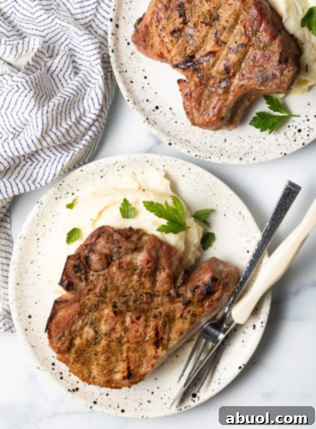 Delicious bone-in smoked pork chop served with creamy mashed potatoes, ready to be enjoyed.