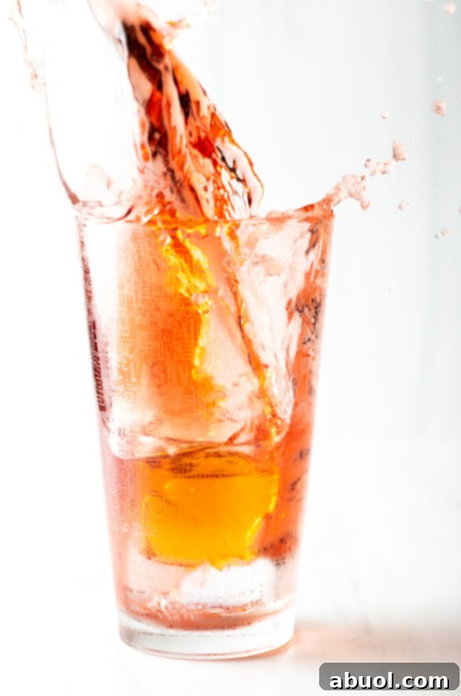 Closeup of a shot of red bull splashing into a Vegas Bomb glass.