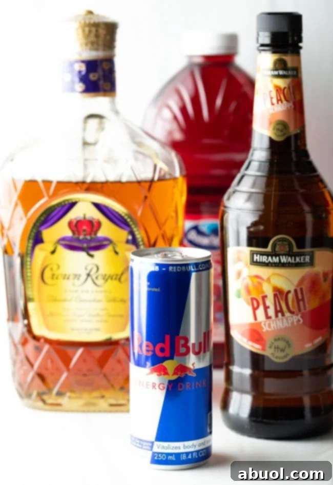 Closeup shot of Vegas Bomb drink ingredients. You see the bottles of Red Bull, peach schnapps, Crown Royal and cranberry juice. 
