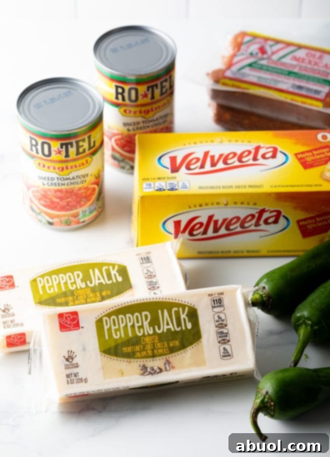 smoked queso ingredients you needs: canned rotel, velveeta cheese, pepper jack cheese, and jalapenos