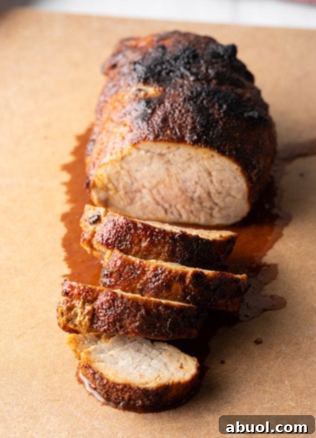 Top-down view of a perfectly sliced air-fried tenderloin on a cutting board, showing its juicy interior.