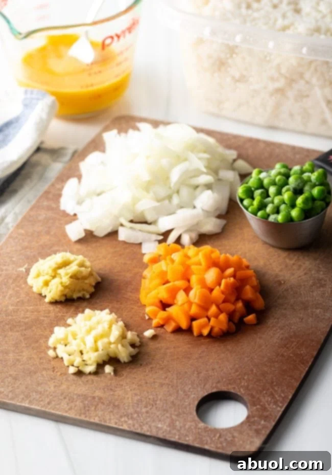 Ingredients for fried rice laid out on a cutting board.