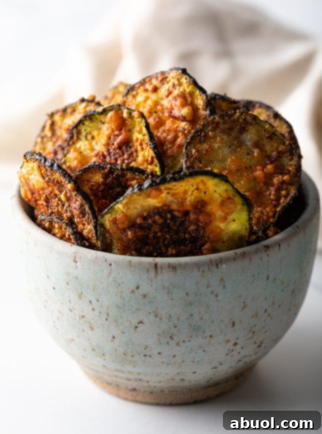 Crispy Air Fryer Zucchini Crisps 2 Close view of a speckled bowl filled with freshly fried zucchini chips.