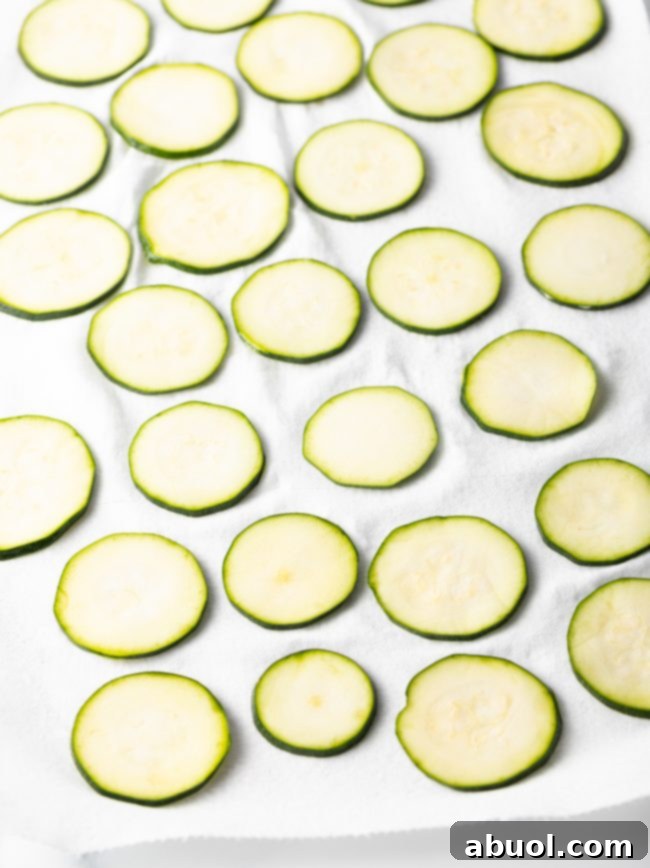 Crispy Air Fryer Zucchini Crisps 7 Raw slices of zucchini laid out on a paper towel.