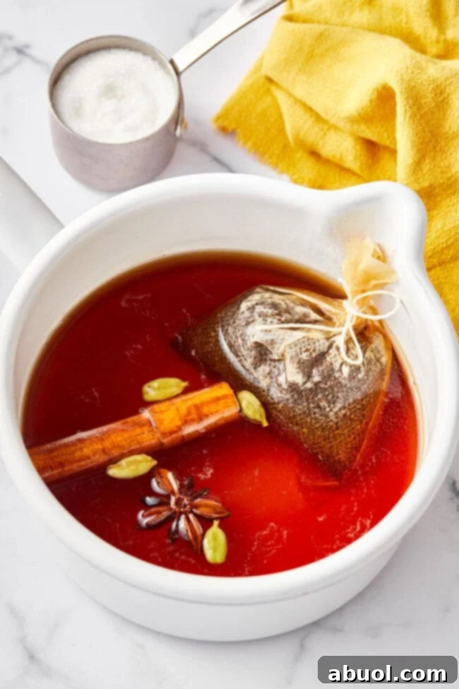 Best Chai tea steeping in a large stock pot with cinnamon, star anise and cardamom pods.