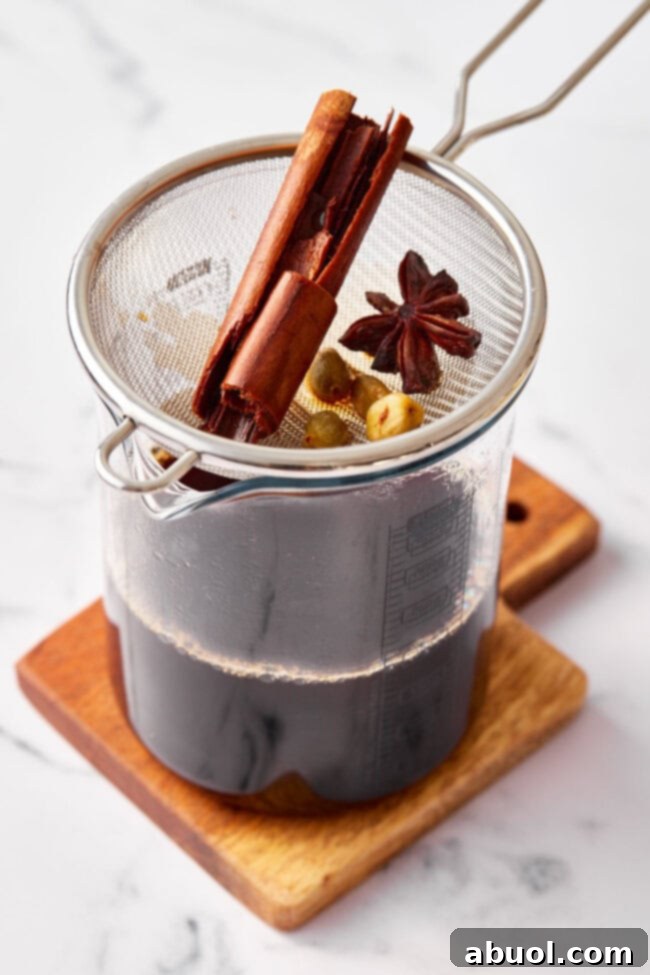Straining chai tea recipe into pitcher.