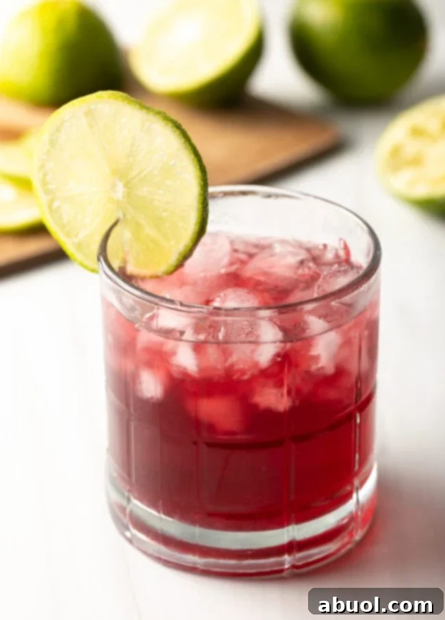 Close view of a transfusion drink, showcasing its vibrant purple hue and a lime garnish.