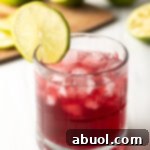 A chilled glass of Transfusion cocktail with lime garnish, ready to be served.