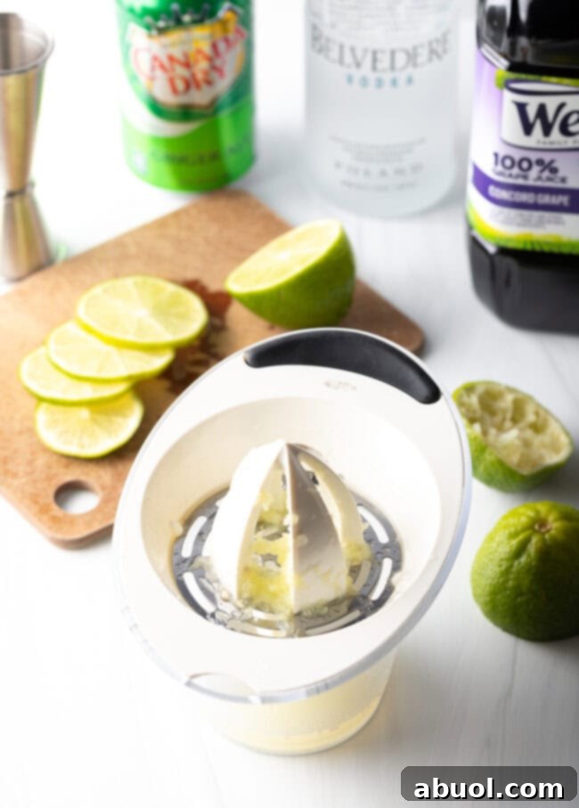 Hand using a manual juicer to extract juice from limes.