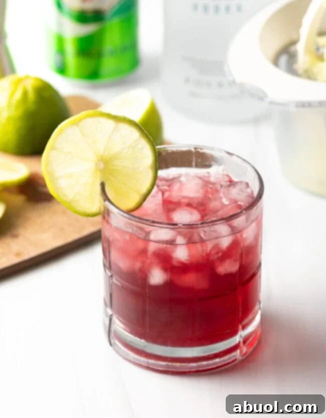 Close-up of a refreshing cocktail in a glass with a lime garnish, ready to be enjoyed.