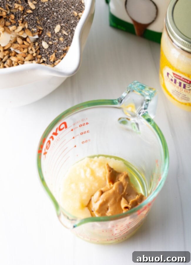 Ultimate Keto Granola Crunch 9 Adding egg whites and other wet ingredients to the ghee and almond butter mixture.