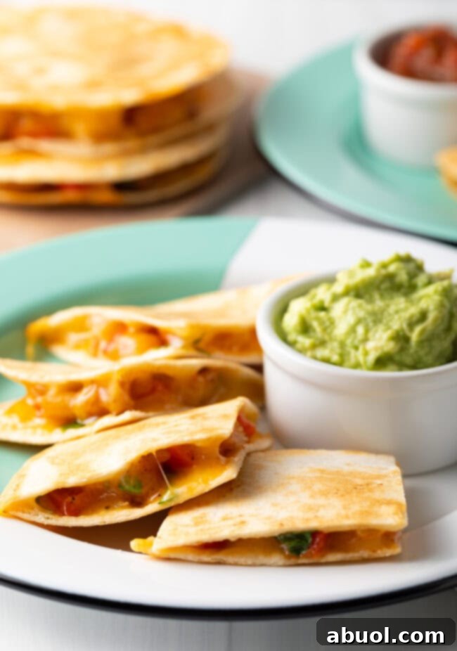 Shrimp quesadilla pieces on a plate with guacamole.