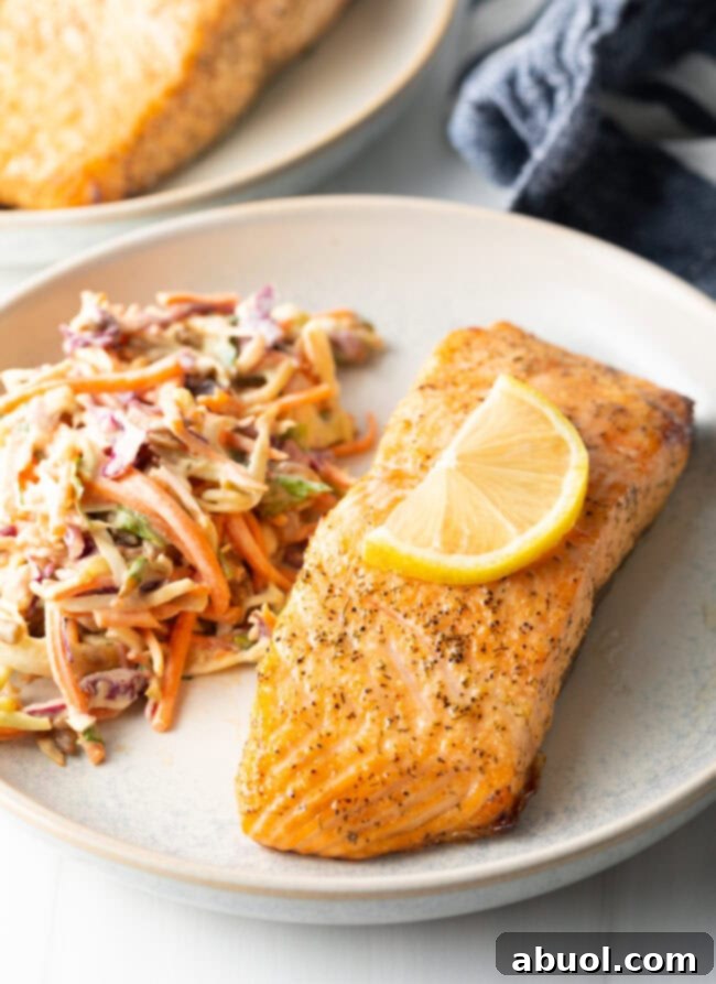 Plate of air-fried salmon with a side of fresh coleslaw.