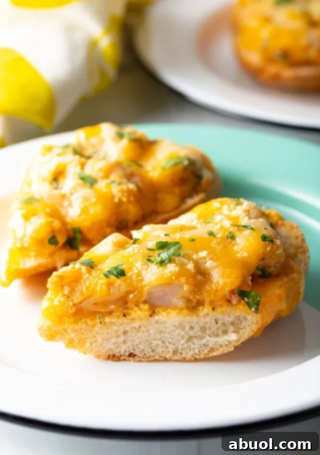 Close-up view of a Cajun shrimp toast recipe, featuring a toasted baguette slice topped with melted cheese, vibrant green parsley, and spicy shrimp.