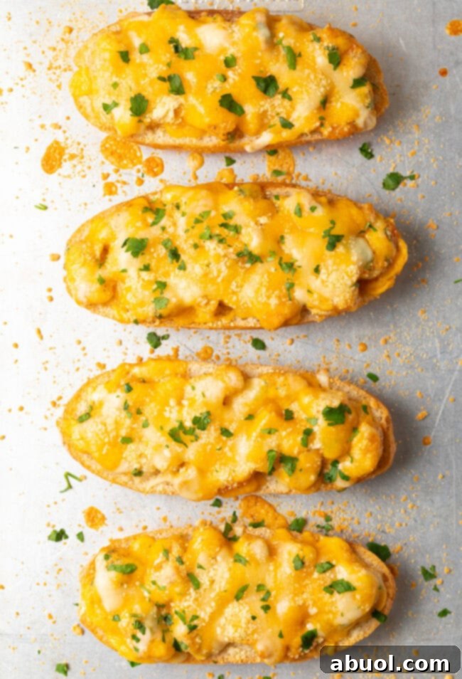 Top-down view of four perfectly baked, cheesy Cajun shrimp toast pieces, garnished with fresh herbs, ready for serving.