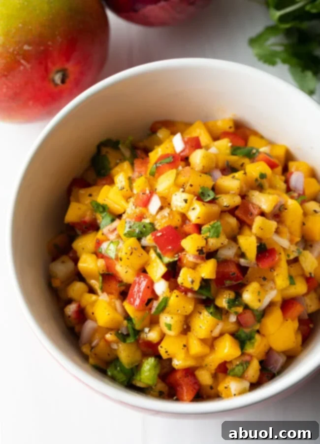 A finished bowl of spicy summer salsa, showcasing the vibrant colors and chunky texture of the peach, mango, and habanero mix.