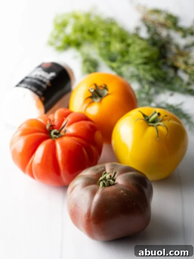 Four multicolored heirloom tomatoes, showing the variety used for the pie.