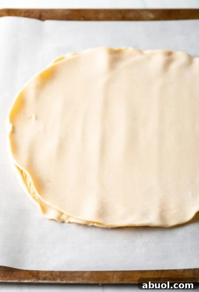 Spreading creamy goat cheese evenly over the pie crust base.
