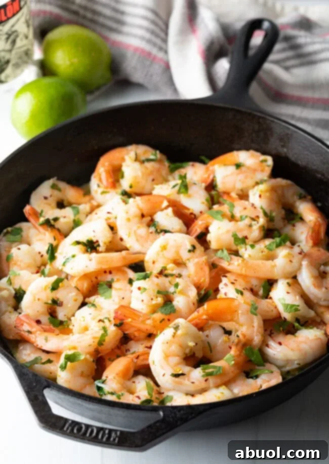Skillet with perfectly cooked tequila lime shrimp, garnished with fresh cilantro.