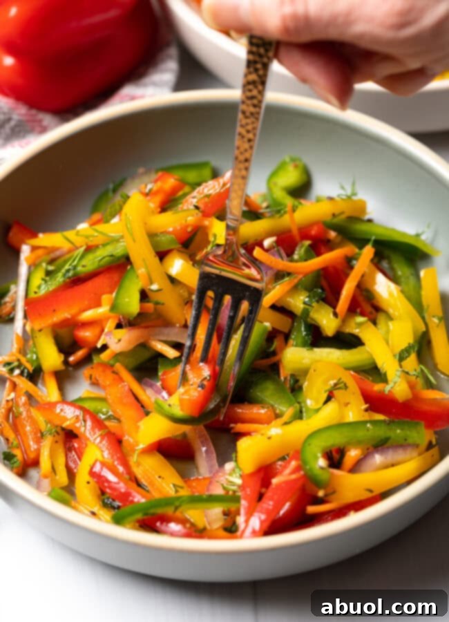 Colorful Pepper Medley 13 A fork taking a bite of vibrant sliced bell peppers from a bowl of salad, highlighting its freshness and inviting texture.