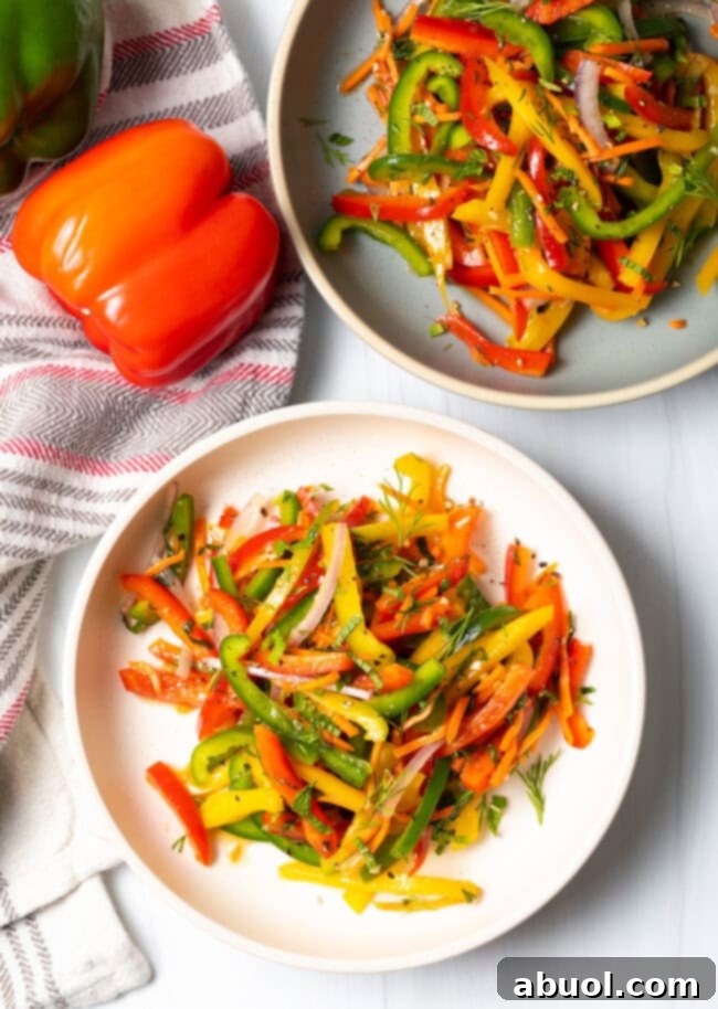 Colorful Pepper Medley 4 Top down view of a vibrant summer bell pepper salad served in a shallow white bowl, showcasing its fresh ingredients and colorful appeal.