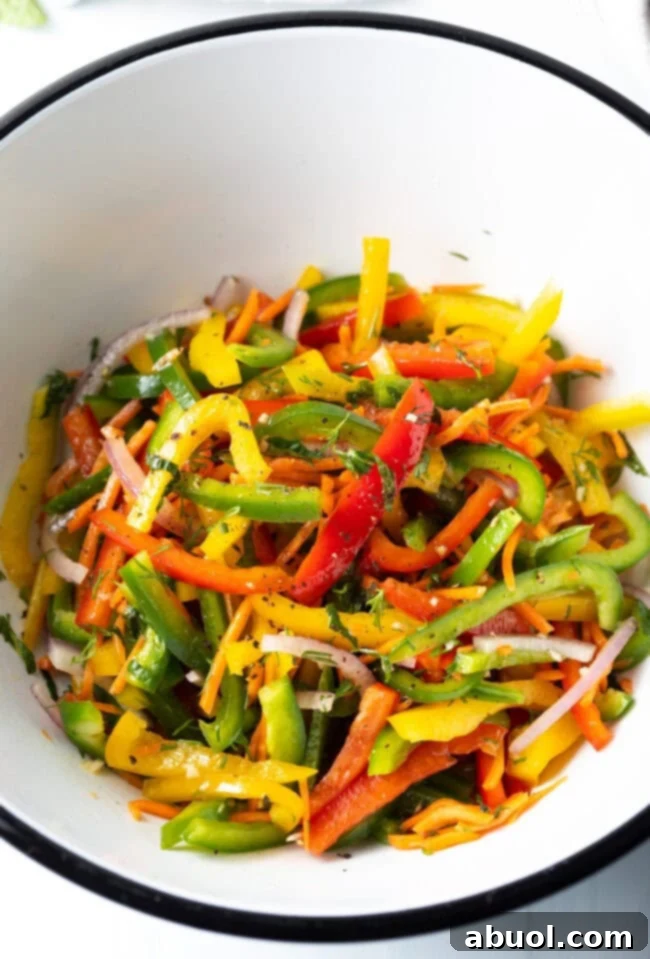 Colorful Pepper Medley 5 A mix of fresh, colorful bell peppers, carrots, and herbs, prepped and ready for slicing, laid out on a cutting board.