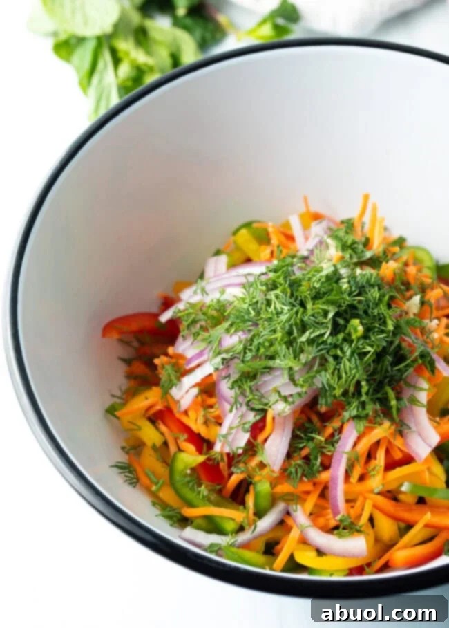 Colorful Pepper Medley 8 Sliced ingredients topped off with a generous amount of freshly chopped dill and mint in a bowl, adding aromatic freshness.