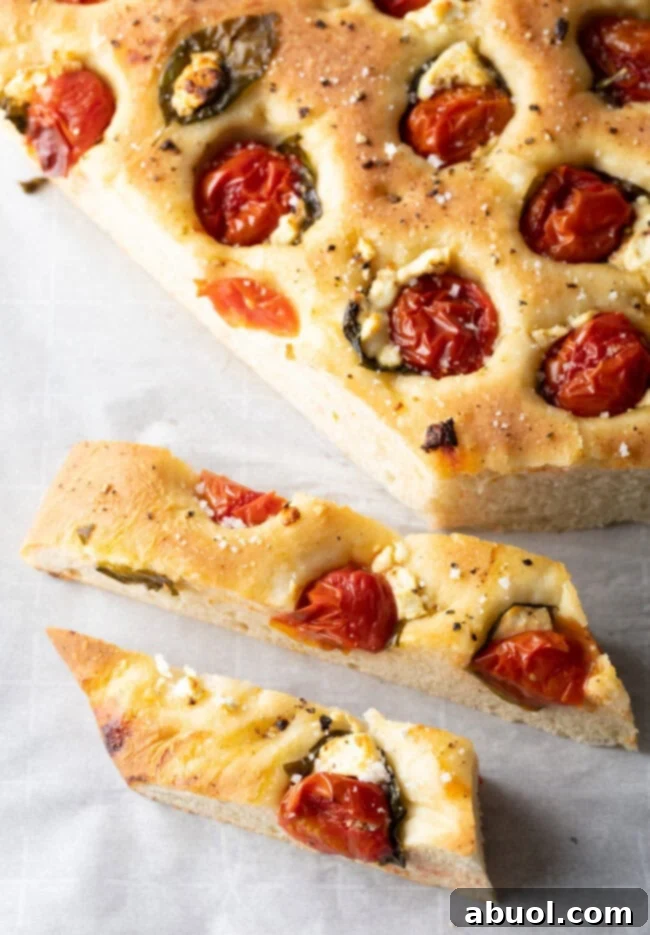 Top-down view of a large tomato basil focaccia loaf cut into long, individual sticks, perfect for dipping.
