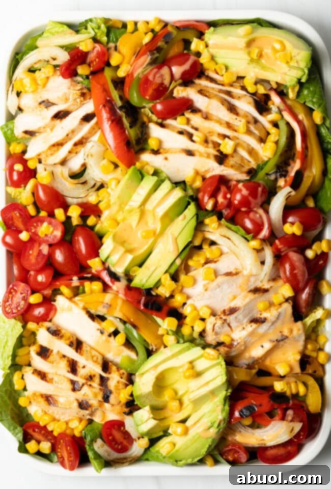 Overhead view of a beautifully arranged chicken fajita salad on a large platter.