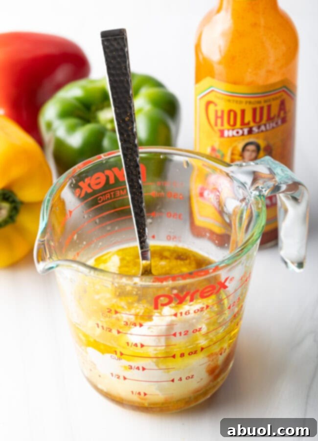 A glass cup showing dressing and marinade being made.