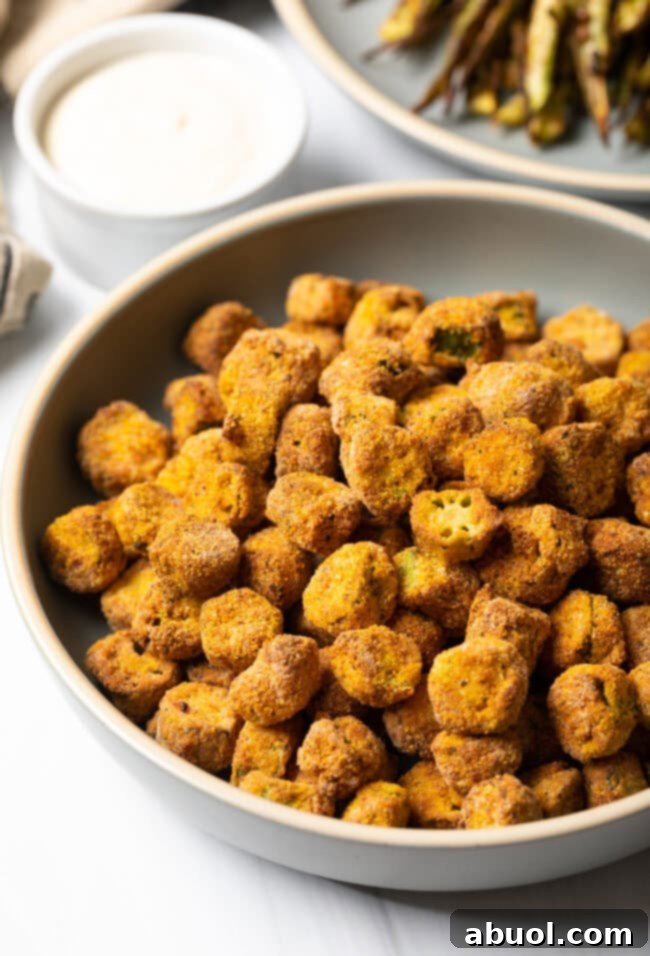 A rustic bowl overflowing with perfectly crunchy, golden breaded fried okra, ready to be enjoyed.