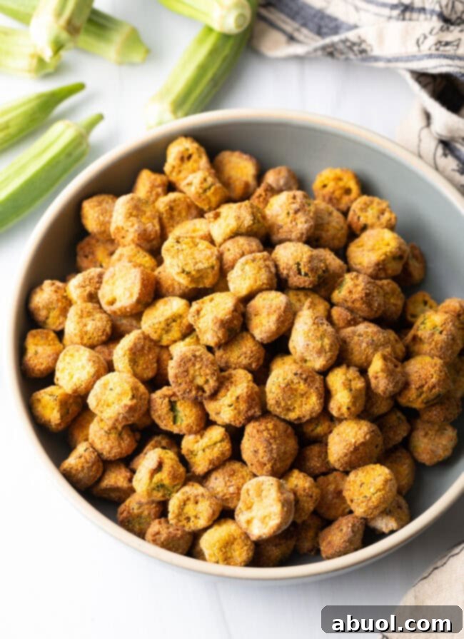 Top down view of a bowl filled with perfectly crunchy air-fried okra pieces, golden brown and inviting.
