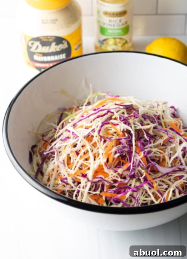 Cabbage and carrots perfectly tossed together in a large mixing bowl, ready for the dressing.