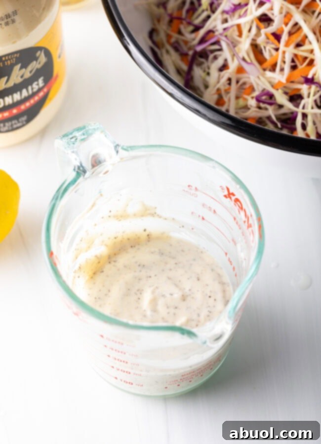 Top down view of creamy slaw dressing in a measuring cup, showcasing its smooth consistency.