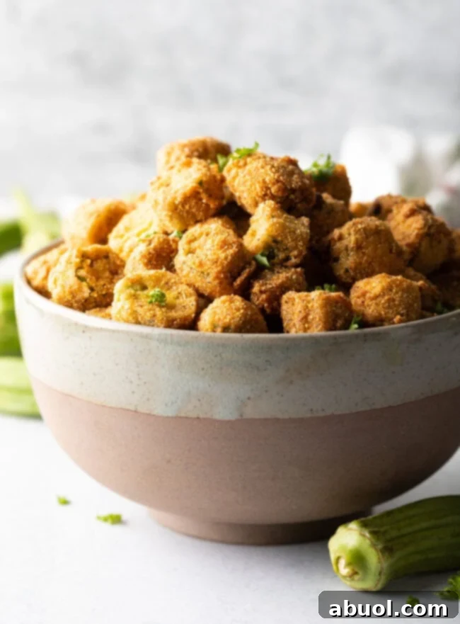 Bowl overflowing with breaded fried okra.
