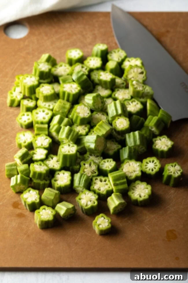 Sliced okra on a cutting board with knife.