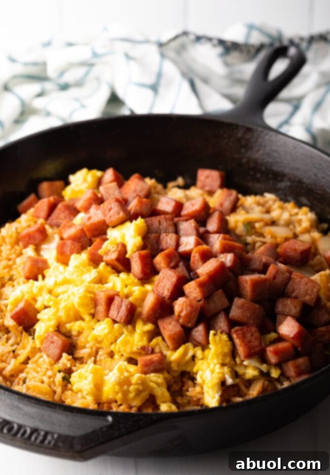 Skillet with rice, eggs, kimchi and cooked chopped spam.