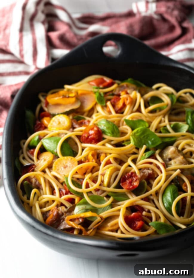 Tossed pasta and veggies in a large bowl.