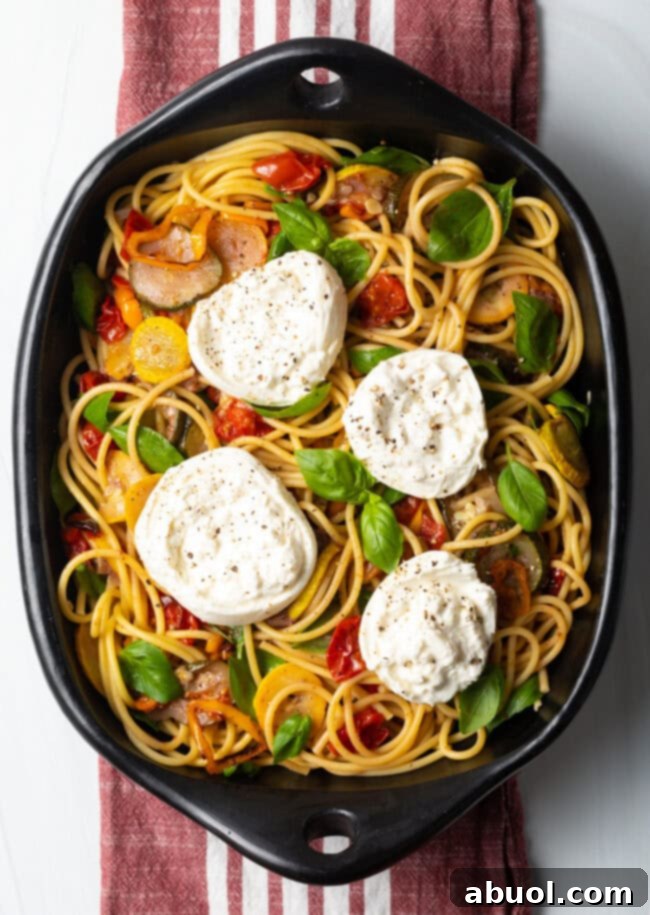 Top down view pasta burrata with roasted summer vegetables.