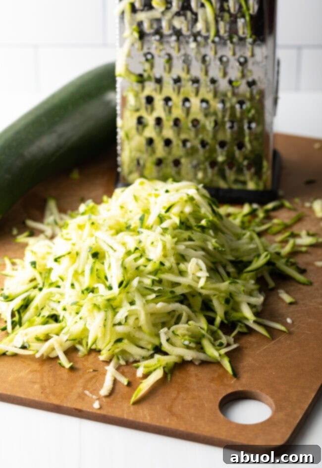 Grated zucchini ready to be cooked on a cheese grater.