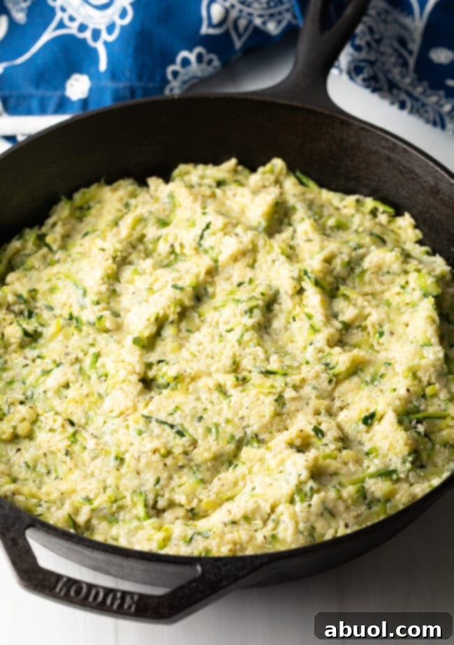 A combination of ingredients smoothed into an even layer in a cast iron skillet, ready for baking.