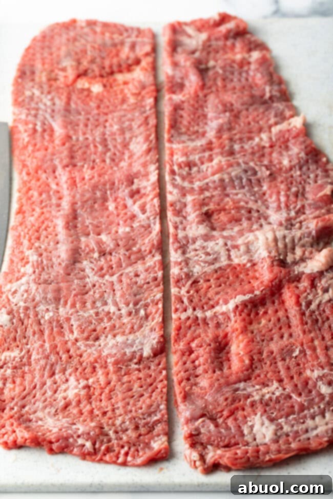 two long pieces of skirt steak flattened thin on a cutting board