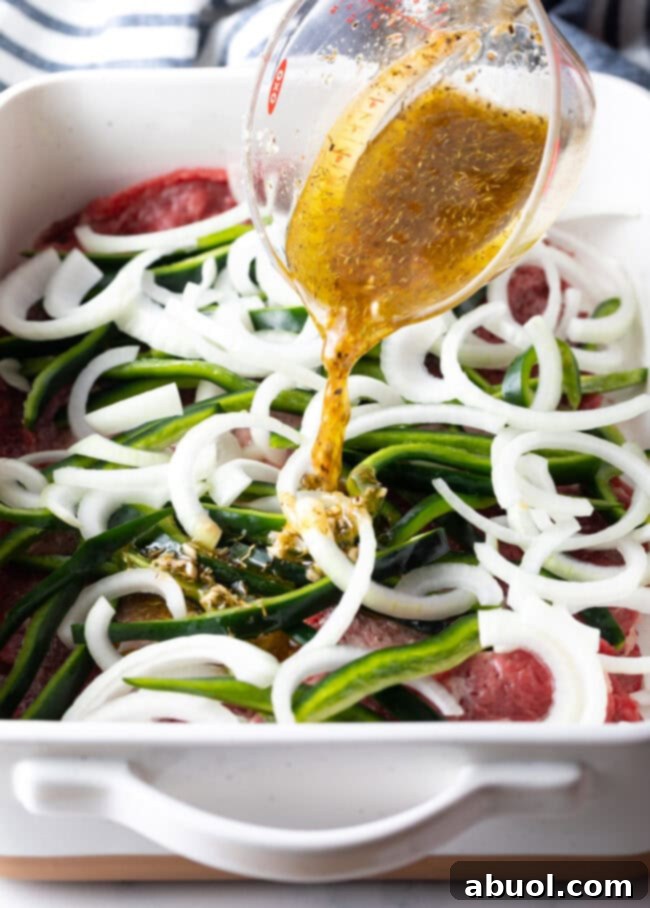 pouring steak marinade over mexican steak, peppers, and onion