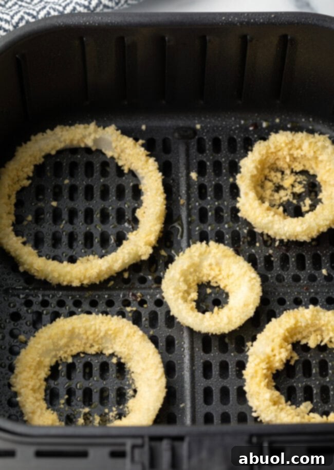 Raw breaded rings in the fryer basket.