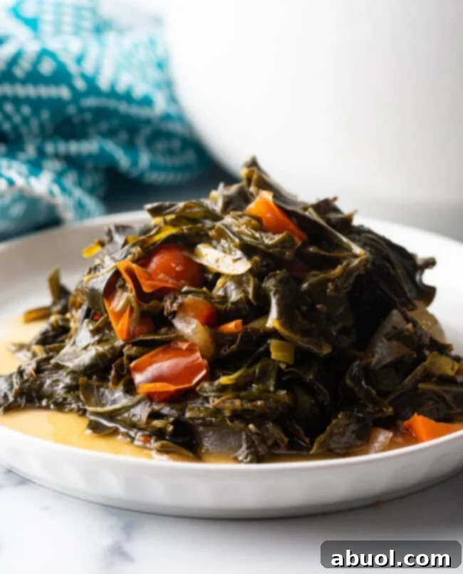 Close side view, small mound of Jamaican collard greens on a white plate.
