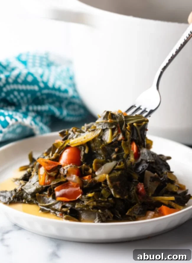 Fork taking bite from plate of callaloo.